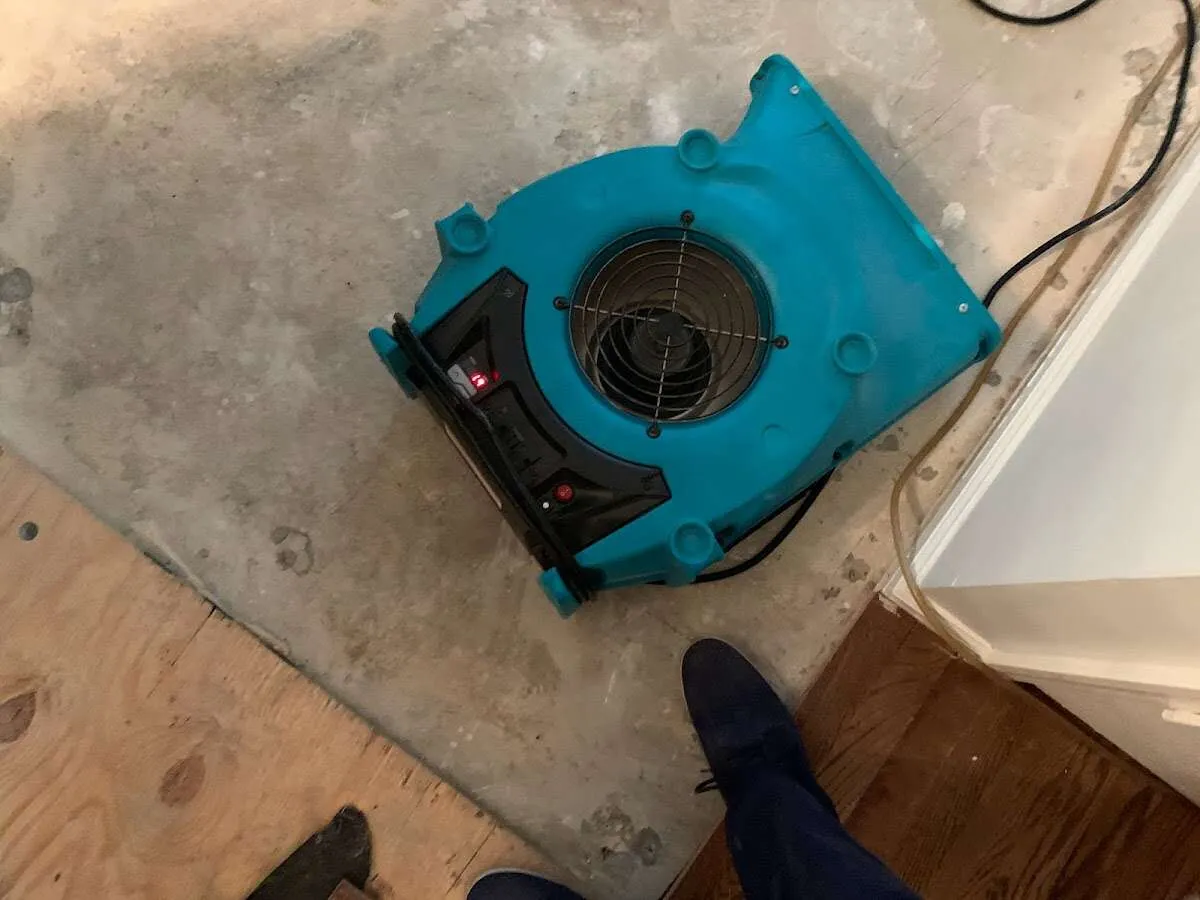 Air mover drying subfloor during Leak Detection & Repair in Lake Mills